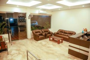 a living room with leather couches and a table at Golden Parrk in Villupuram