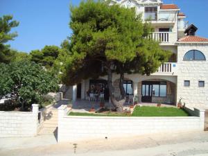 a large building with a tree in front of it at Villa Adagio Apartments in Sumartin