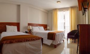 a hotel room with two beds and a window at Retama Hotel in Tacna