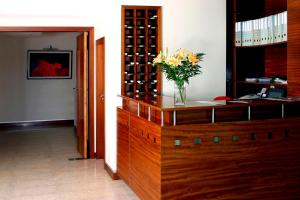 a vase of flowers sitting on top of a wooden cabinet at Hotel Paulo VI in Rio Maior