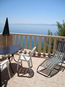 a patio with a table and chairs and the ocean at Villa Adagio Apartments in Sumartin