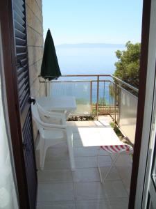 a balcony with a table and chairs and the ocean at Villa Adagio Apartments in Sumartin
