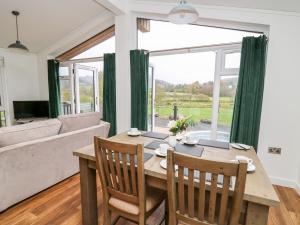 a dining room with a table and chairs and a large window at Sycamore Lodge in Llanidloes