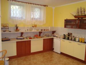 a large kitchen with yellow walls and white counters at Villa Adagio Apartments in Sumartin