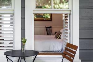 eine Veranda mit einem Tisch und einem Bett in einem Zimmer in der Unterkunft Brannan Cottage Inn in Calistoga