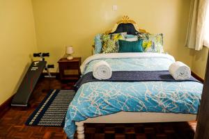 een slaapkamer met een bed met een blauw dekbed bij Royal Strata House in Nanyuki