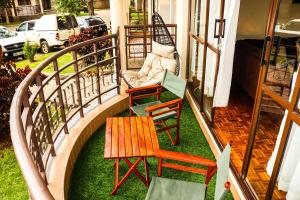 balkon z 3 krzesłami i stołem na nim w obiekcie Royal Strata House w mieście Nanyuki
