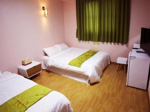 Jeju R Hotel & Guesthouse tesisinde bir odada yatak veya yataklar