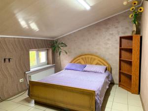 a bedroom with a bed with purple sheets and a window at Sun in Khmelnytskyi