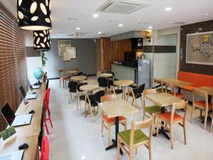 a restaurant with tables and chairs in a room at Jeju R Hotel & Guesthouse in Jeju
