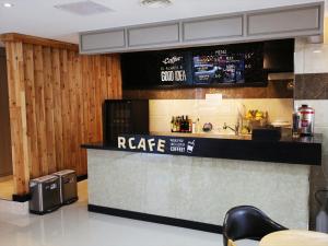 a restaurant with a counter with a coffee bar at Jeju R Hotel & Guesthouse in Jeju