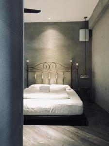 - une chambre avec un lit blanc et une tête de lit en métal dans l'établissement 80 Colonie Fraser's Hill, à Bukit Fraser