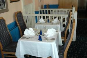 duas mesas num restaurante com toalhas de mesa brancas em Preston Park Hotel em Brighton & Hove
