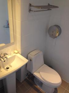 a white bathroom with a toilet and a sink at Jeju R Hotel & Guesthouse in Jeju