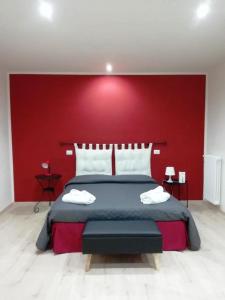 een slaapkamer met een groot bed met een rode muur bij Casa Tintilia in Isernia