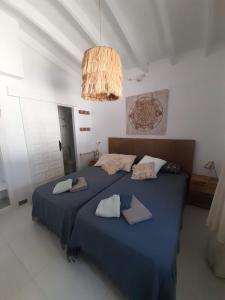 1 Schlafzimmer mit 2 Betten mit blauer Bettwäsche und einem Kronleuchter in der Unterkunft Casa Verano eterno, Villa tot 16 personen in Benissa