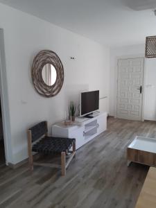 ein Wohnzimmer mit einem Fernseher an einer weißen Wand in der Unterkunft Casa Verano eterno, Villa tot 16 personen in Benissa + 37 Fotos