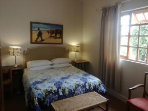 a bedroom with a bed with a blue and white blanket at Valley Guest House in Port Elizabeth