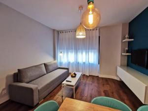 a living room with a couch and a table at Apartamento RAL5021 en Triana junto al centro in Seville