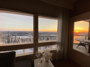 a room with two windows with a view of snow covered trees at Tunturi Panorama Iso-Syöte in Syöte