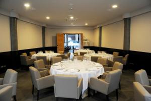 シウダー・レアルにあるCumbria Spa Hotel 3* Supのテーブルと椅子(白いテーブルクロス付)が備わる客室です。