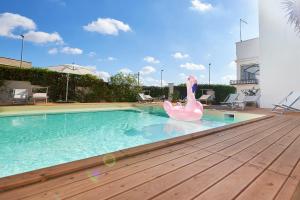 un cisne rosa en medio de una piscina en Lapilanoa - Suite & Pool, en Nardò
