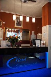 a hotel terminal with a reception desk with flowers on it at Hotel Continental Amsterdam in Amsterdam