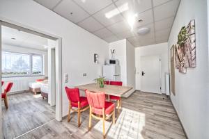 a kitchen and dining room with a table and red chairs at Apartment Lichtenwald in Thomashardt