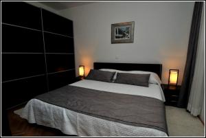 a bedroom with a large bed and two lamps at Apartment Karmen in Dubrovnik