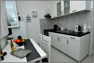 a kitchen with white cabinets and a counter top at Apartment Karmen in Dubrovnik