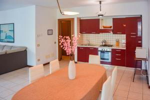 una cocina con una mesa con un jarrón de flores. en Bellagio Villas, en Lezzeno