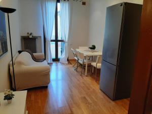 un soggiorno con tavolo e frigorifero di HOME ALTINATE a Padova