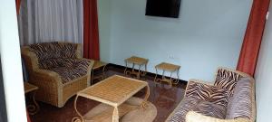 a living room with two chairs and a table at Sumawe Suites in Karatu