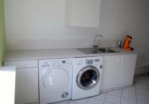 a kitchen with a washing machine and a sink at Modernes-Wohnen-im-Bungalow in Quickborn