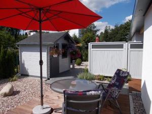 a patio with a table and a red umbrella at Modernes-Wohnen-im-Bungalow in Quickborn
