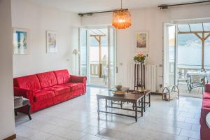 a living room with a red couch and a table at Bellagio Villas in Lezzeno