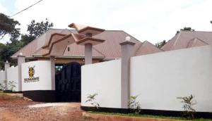 a white fence in front of a house at Sumawe Suites in Karatu