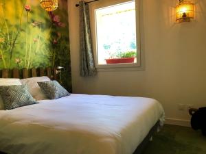 a bedroom with two beds and a window with a flower mural at La Ferme des Étroits in Valloire