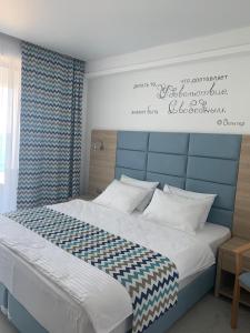 a bedroom with a large bed with a blue headboard at La Familia in Loo