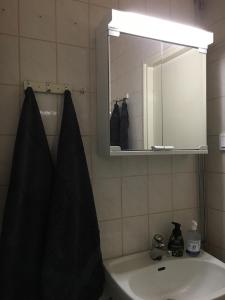 een badkamer met een wastafel en een spiegel bij Viihtyisä asunto keskustassa palvelujen lähellä in Heinola