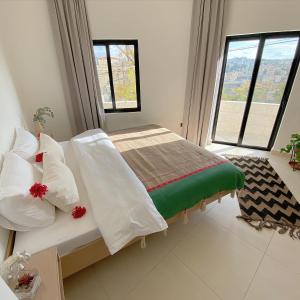 una camera da letto con un letto con cuscini bianchi e una finestra di Nu Fifty Two ad Amman