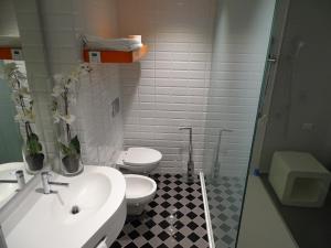 a bathroom with a white sink and a toilet at Green Hotel Motel in Vergiate