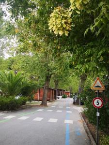 une rue vide avec un arbre et un panneau limitant la vitesse dans l'établissement Campeggio Italia, à Marina di Massa