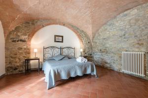 een slaapkamer met een bed in een stenen muur bij Agriturismo San Ottaviano in Monterotondo