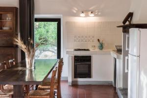 a kitchen with a dining room table and a refrigerator at Agriturismo San Ottaviano in Monterotondo