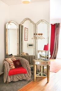 een woonkamer met een bank, een tafel en spiegels bij A La Villa Boucicaut in Chalon-sur-Saône