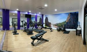 a gym with tread machines and a large mural at Gran Hotel Don Manuel in Cáceres