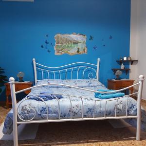 - une chambre dotée d'un lit avec un mur bleu dans l'établissement B&B Da Andreina, à Guspini