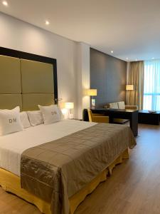 a hotel room with a large bed and a desk at Gran Hotel Don Manuel in Cáceres