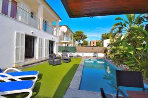 une cour avec une piscine et de l'herbe verte dans l'établissement Villa Siulador 107 by Mallorca Charme, à Playa de Muro